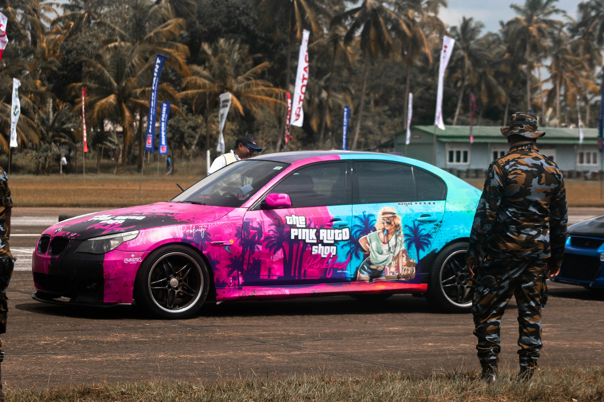 a pink car with a man standing next to it
