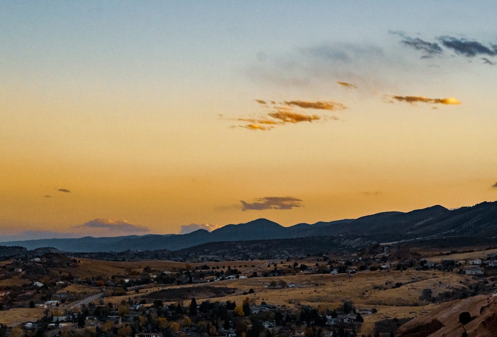 a view of a town and mountains at sunset
