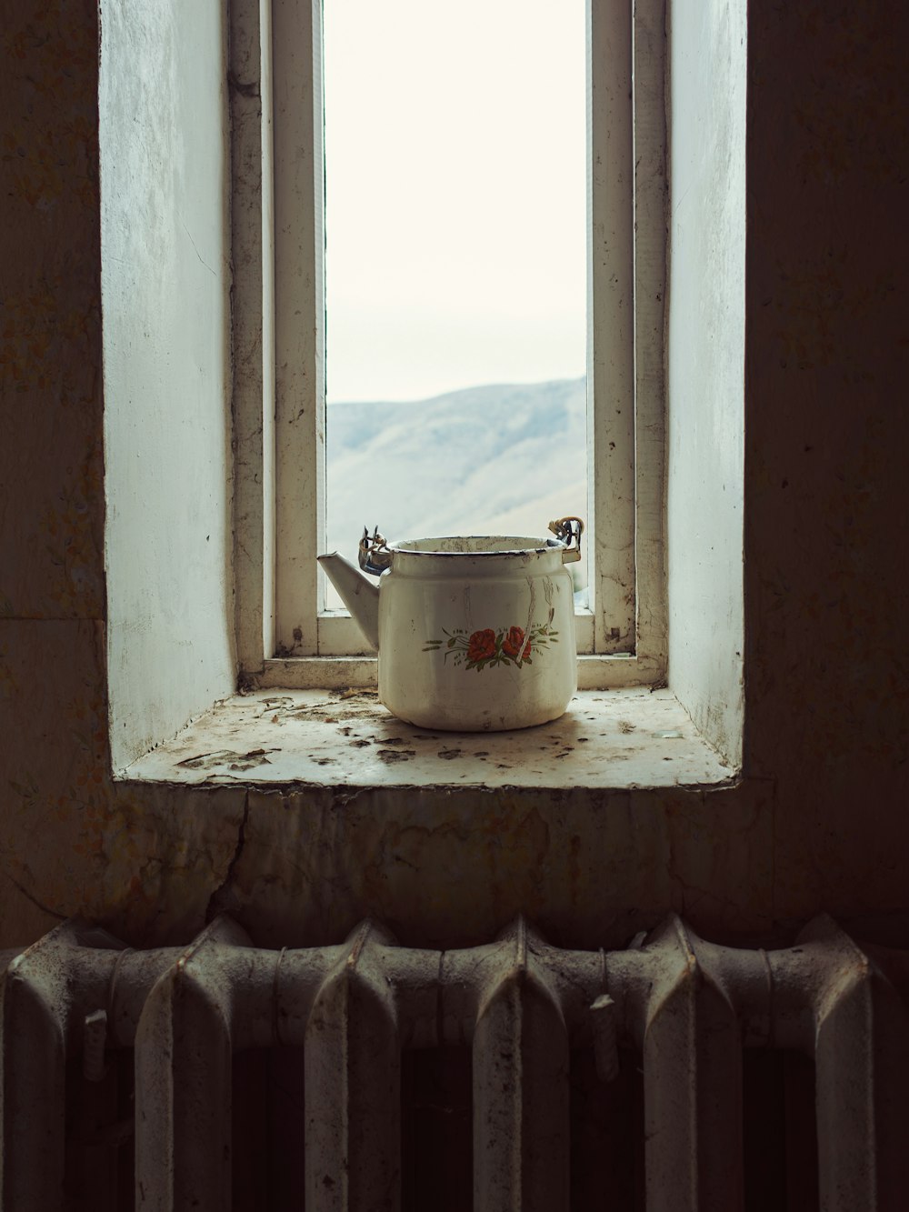 un vaso bianco seduto in cima al davanzale di una finestra