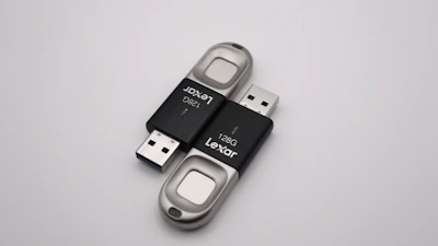 Three different USB flash drives in vibrant colors, arranged neatly on a white surface.