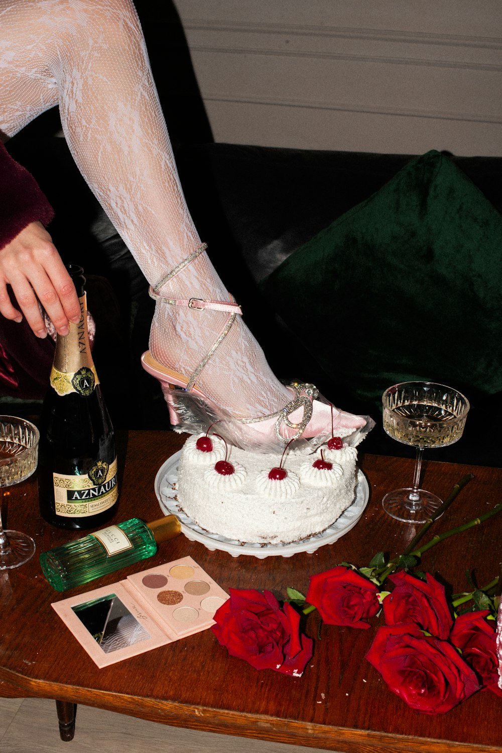a woman in high heels is pouring champagne into a cake