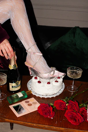 a woman in high heels is pouring champagne into a cake