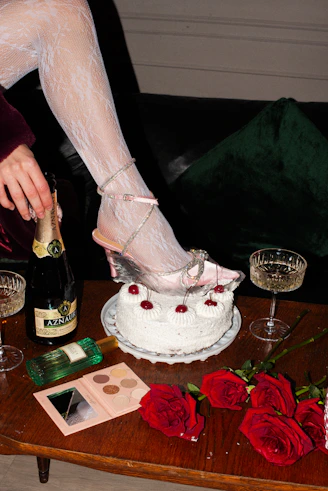 a woman in high heels is pouring champagne into a cake