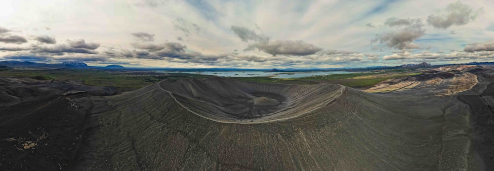 a panoramic view of a mountain with clouds in the sky