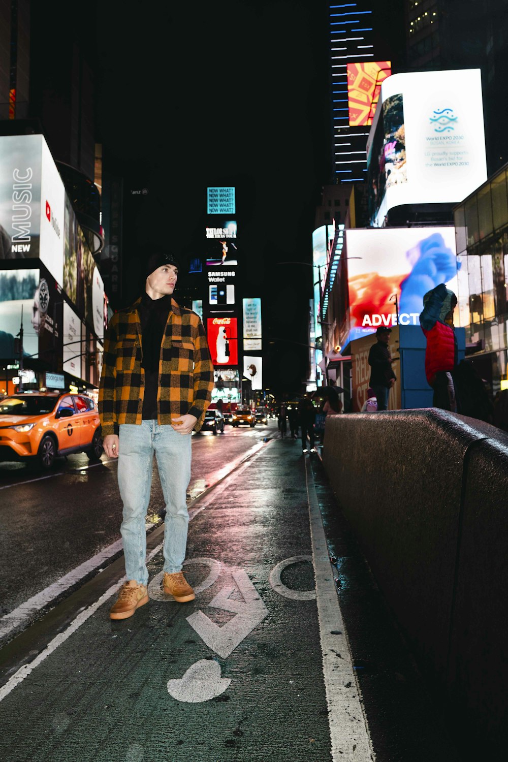 a man standing on a city street at night