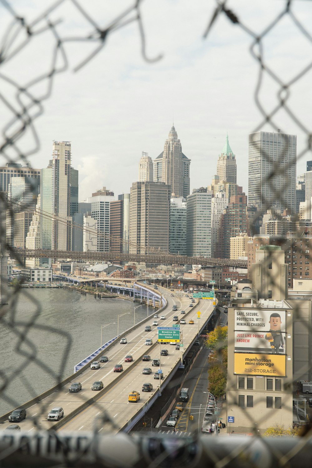 a view of a city from behind a chain link fence