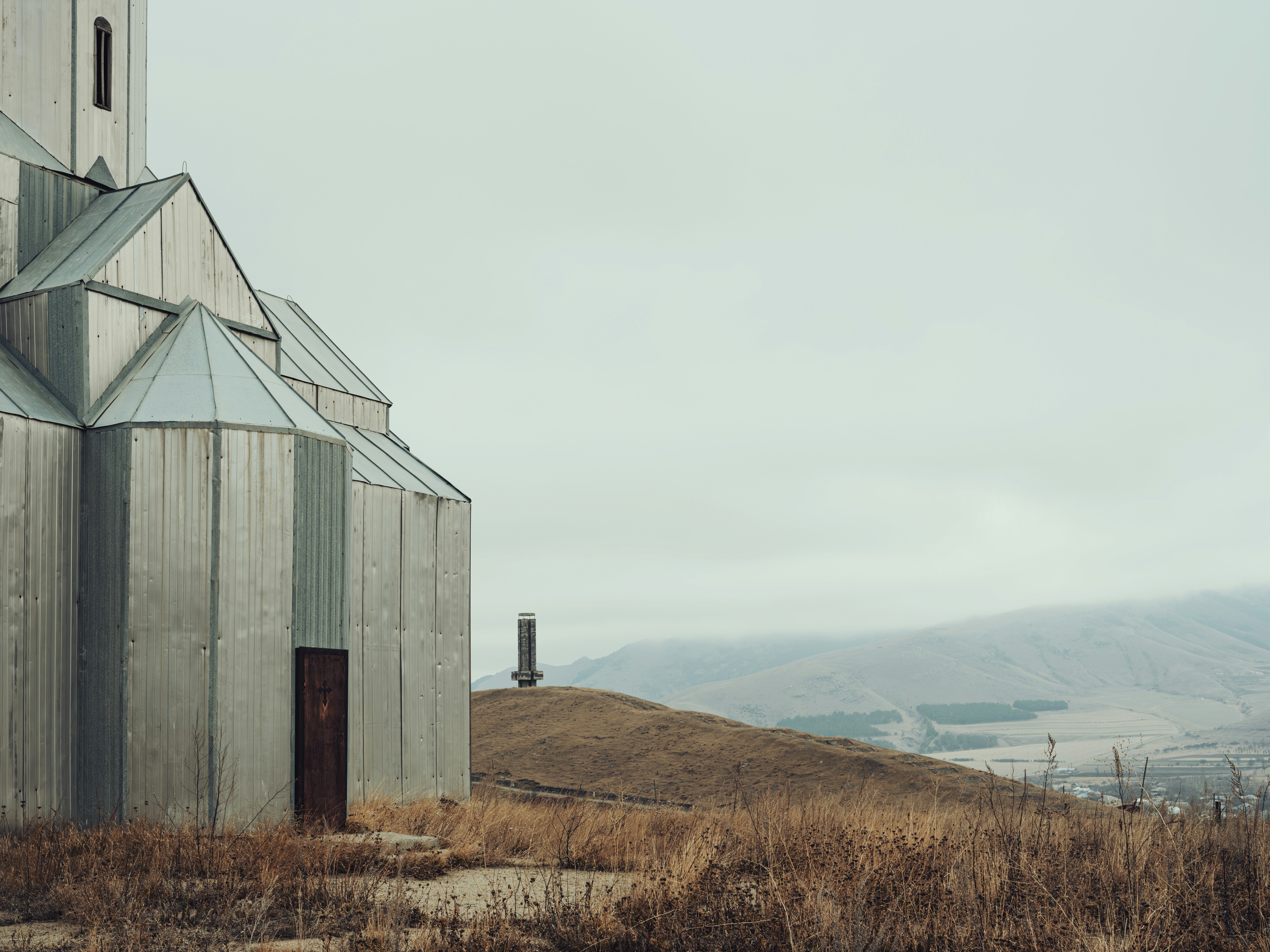 an old church with a steeple on a hill