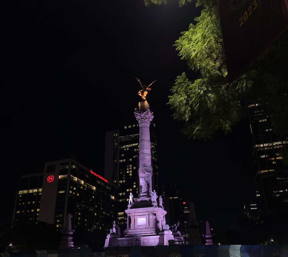 a statue in the middle of a city at night