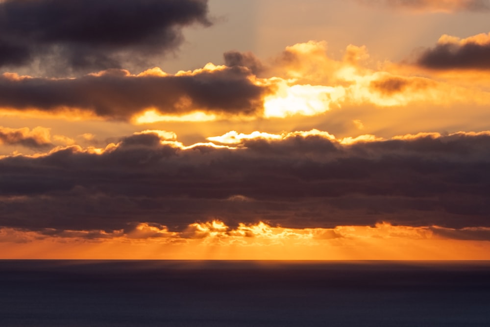 the sun is shining through the clouds over the ocean