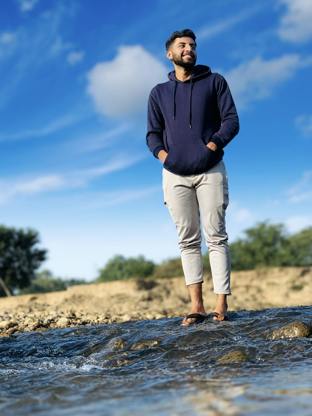 a man standing on a rock in the middle of a river