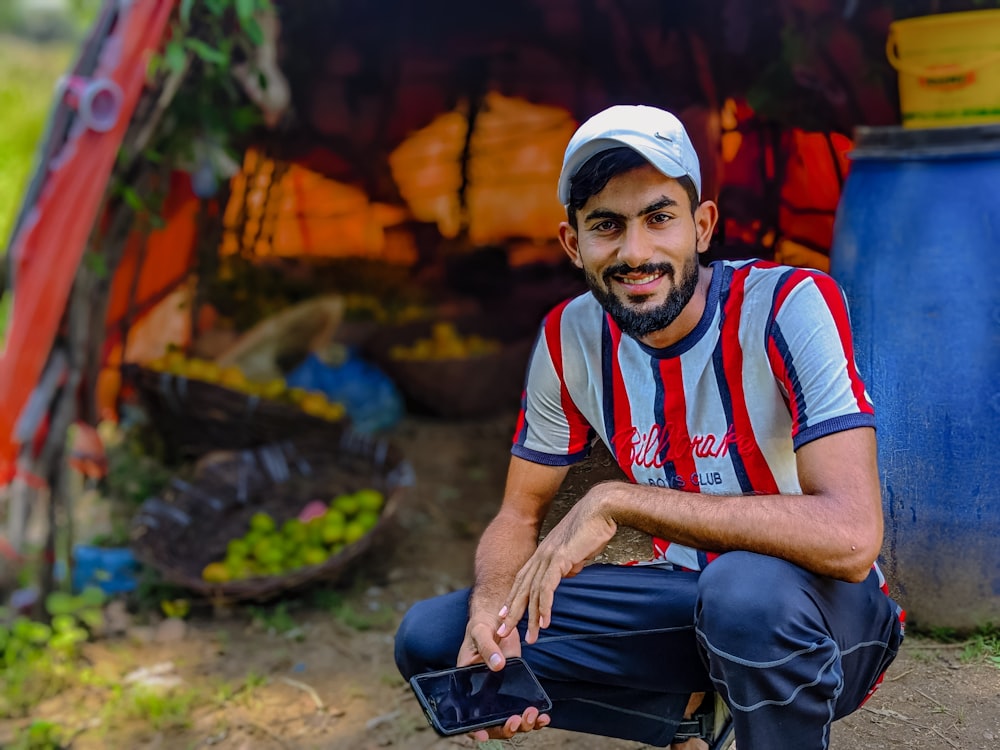 a man sitting on the ground in front of a tent