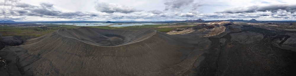 a panoramic view of a mountain with a lake in the distance