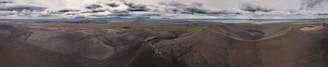 Panoramic shot of the volcanic landscape on the Lava Tour route with a jeep in the foreground.