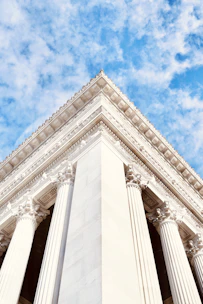 a tall white building with columns under a blue sky
