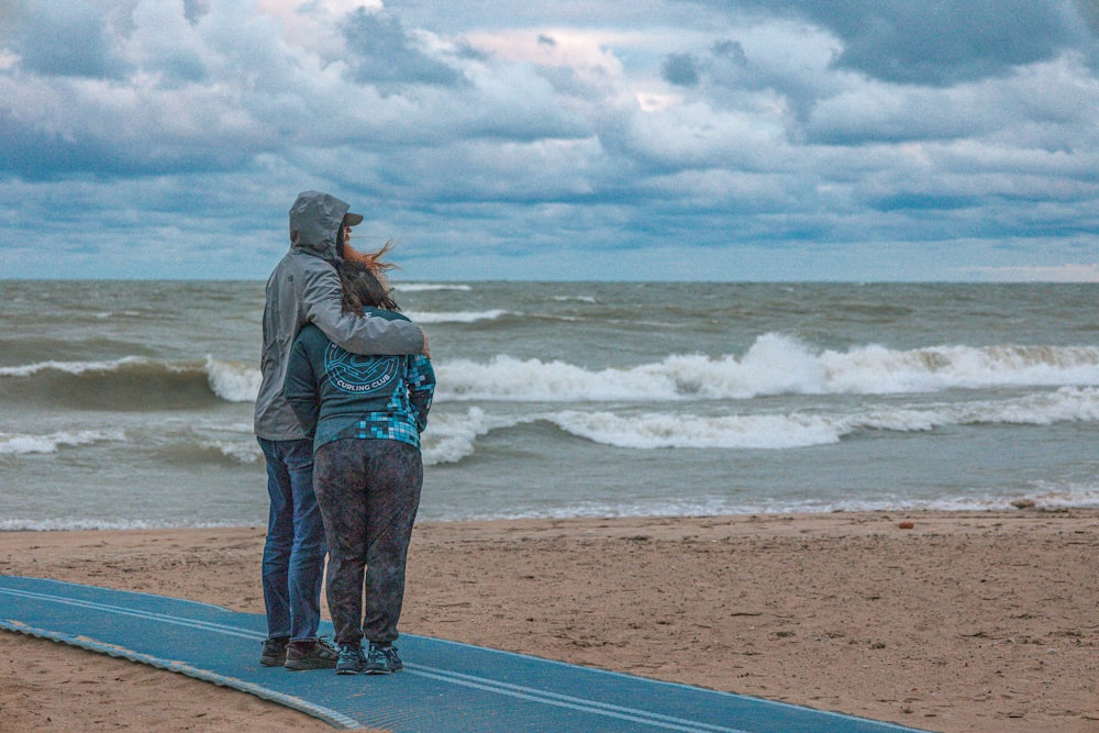 a couple of people standing on top of a surfboard