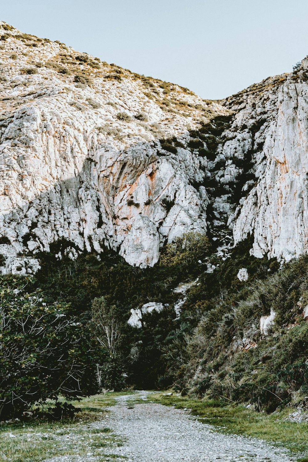 a dirt road in front of a mountain