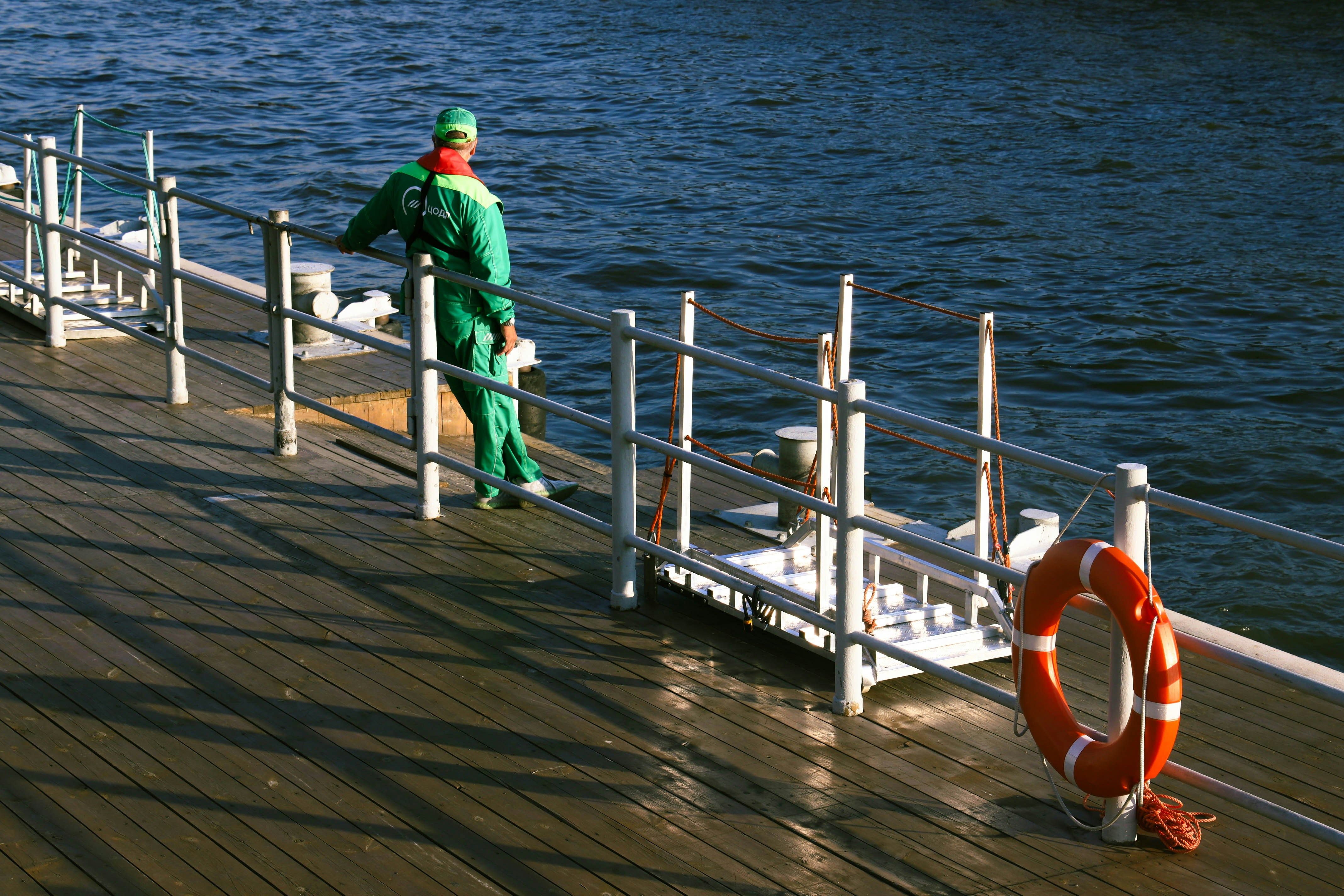 of a person inspecting the chains and hardware on a floating dock - anchor floating dock
