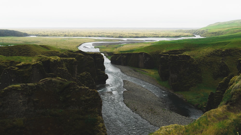 a river flowing through a lush green valley