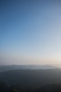 A serene landscape of overlapping mountain ranges at dawn, reflecting the foundation’s cyan and teal palette
