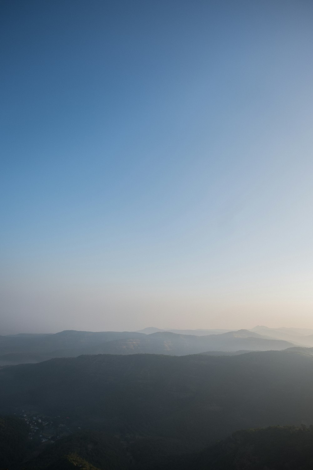 a view of a mountain range with a blue sky in the background