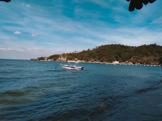 A serene coastal sunrise with a small boat gently floating near the shore.
