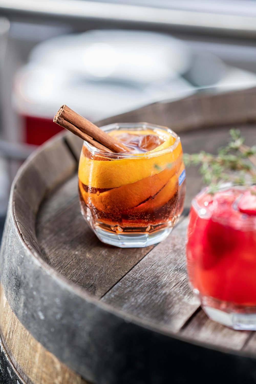 two glasses of alcohol sitting on a barrel