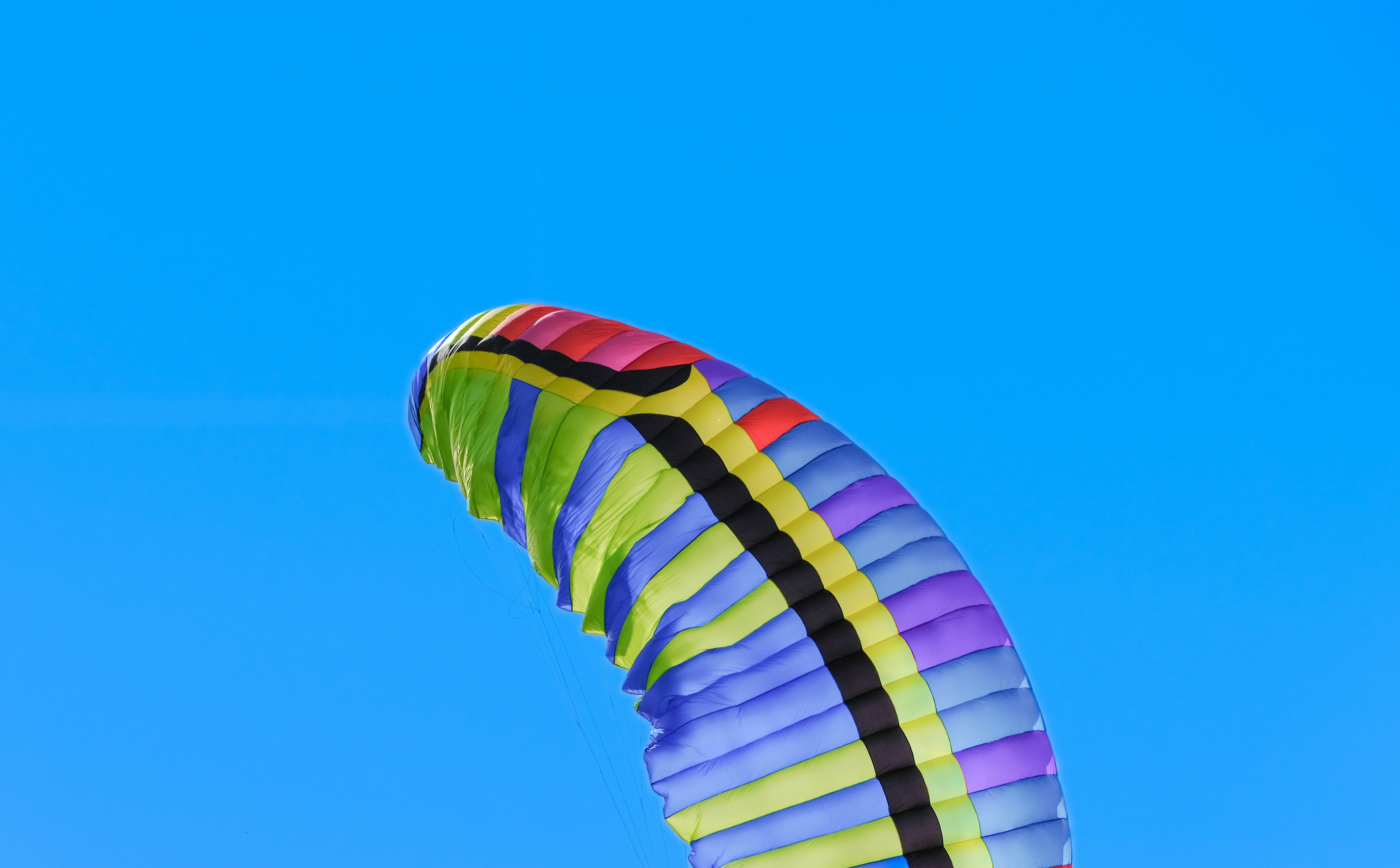 a colorful kite flying in a blue sky