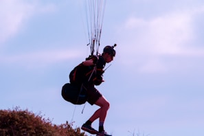 A beginner pilot preparing for takeoff on a sunny hillside with instructor guidance.