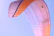Close-up of a smiling first-time paraglider preparing for takeoff with a colorful wing.