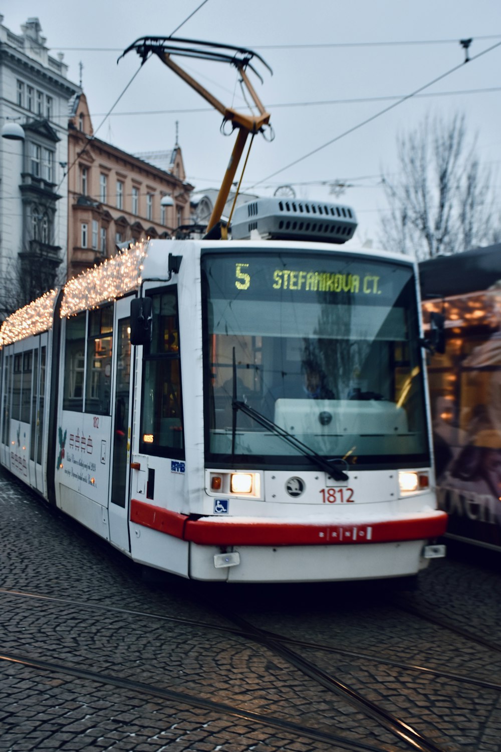 a white and red trolley on a city street