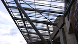 Steel beams being installed on a modern building frame under a clear sky