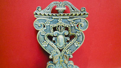 A rustic wooden craft piece with detailed carvings, resting on an earthy-toned fabric.