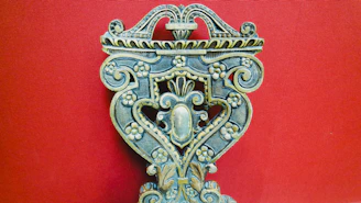 A rustic wooden craft piece with detailed carvings, resting on an earthy-toned fabric.
