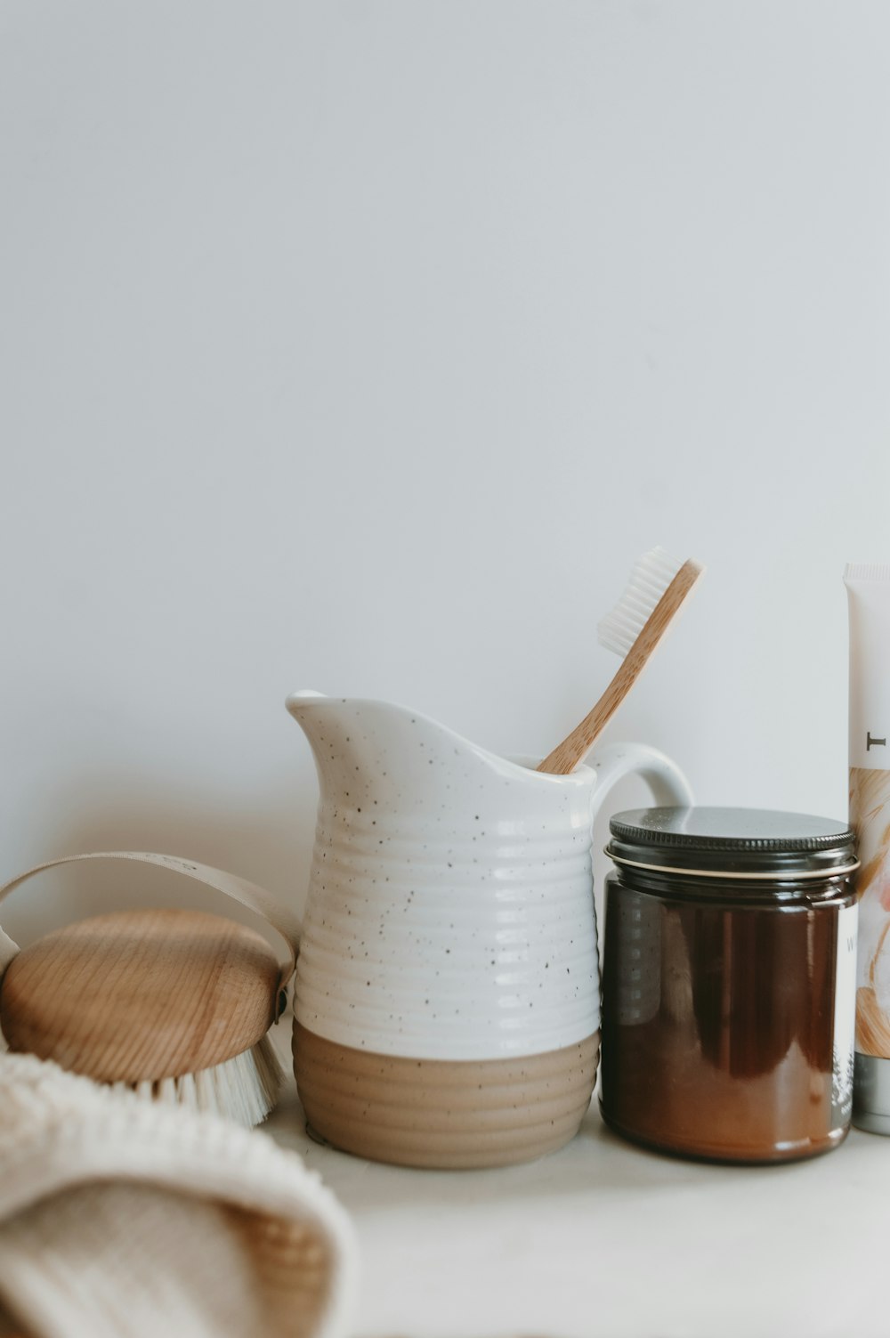 a table topped with a jar of cream and a toothbrush