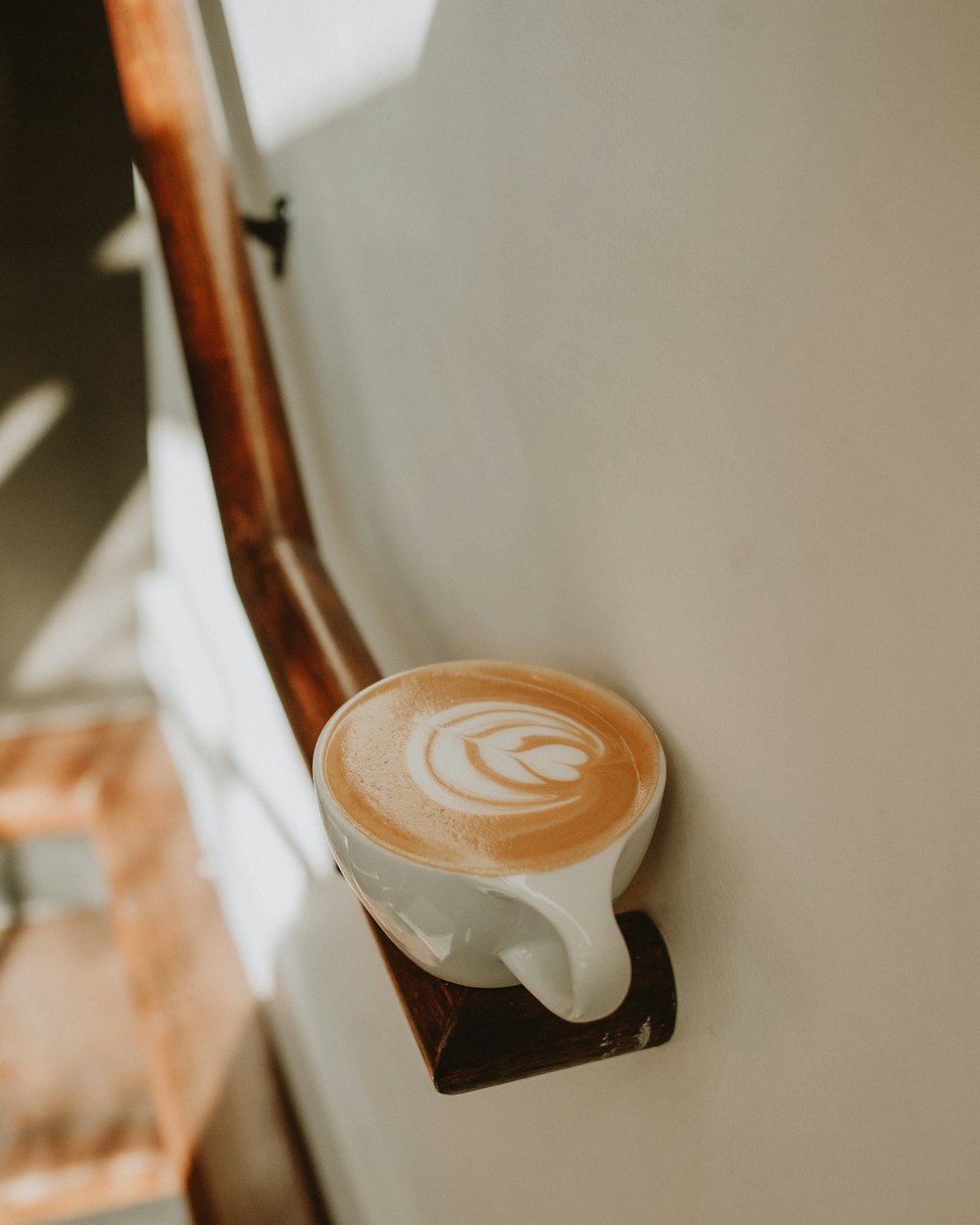 a cup of coffee sitting on top of a wooden stand