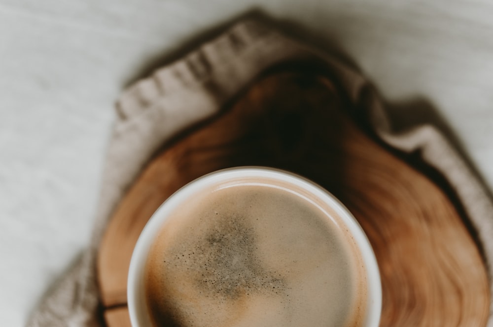 a cup of coffee sitting on top of a wooden tray