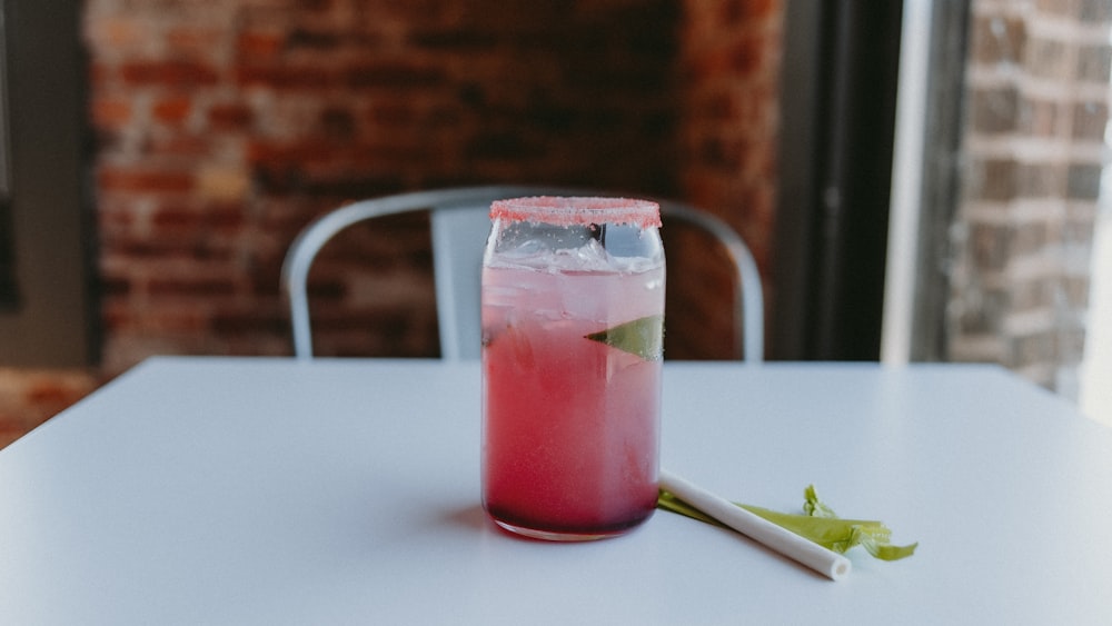 a pink drink sitting on top of a white table