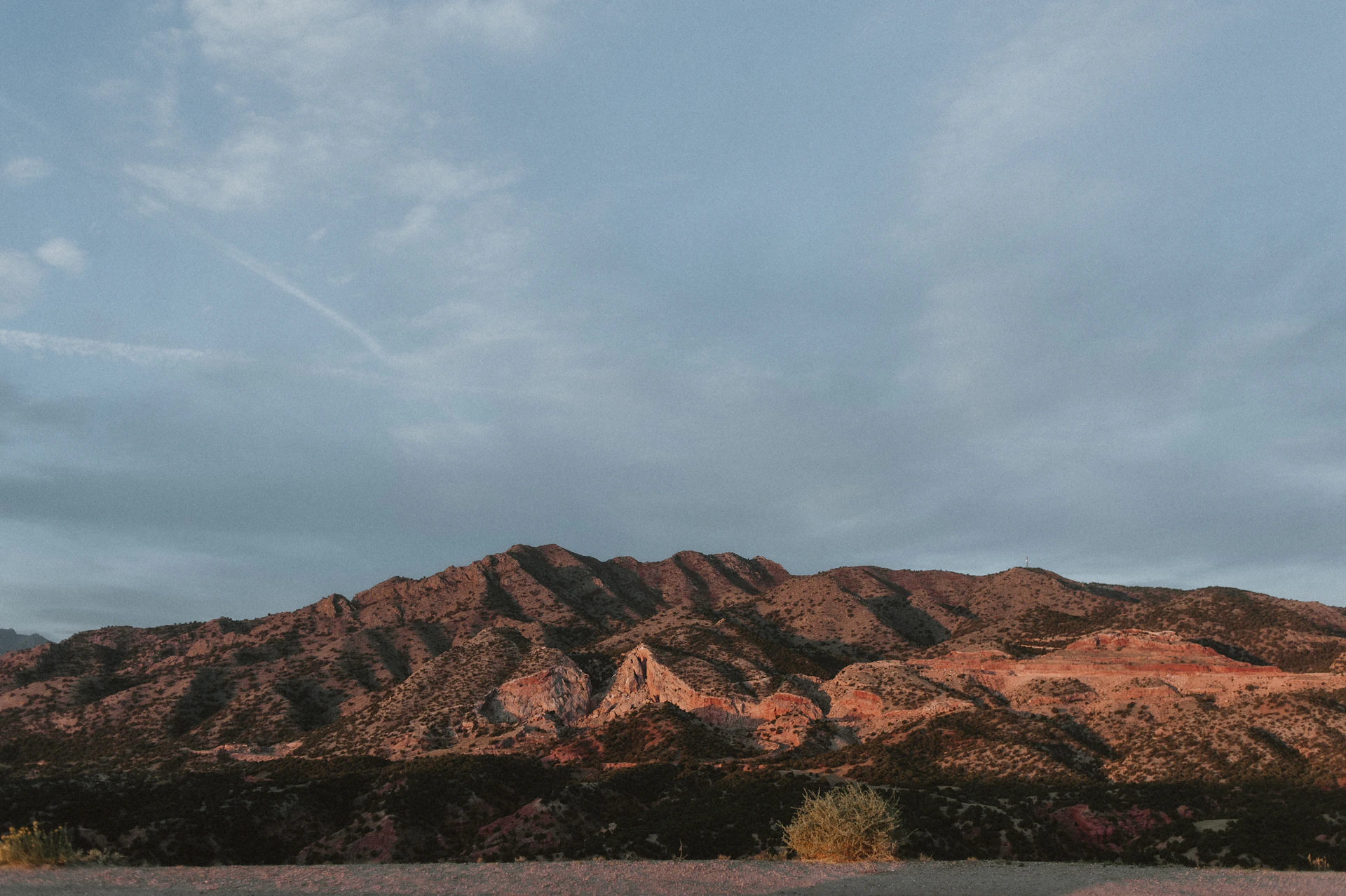 a mountain range with a few clouds in the sky