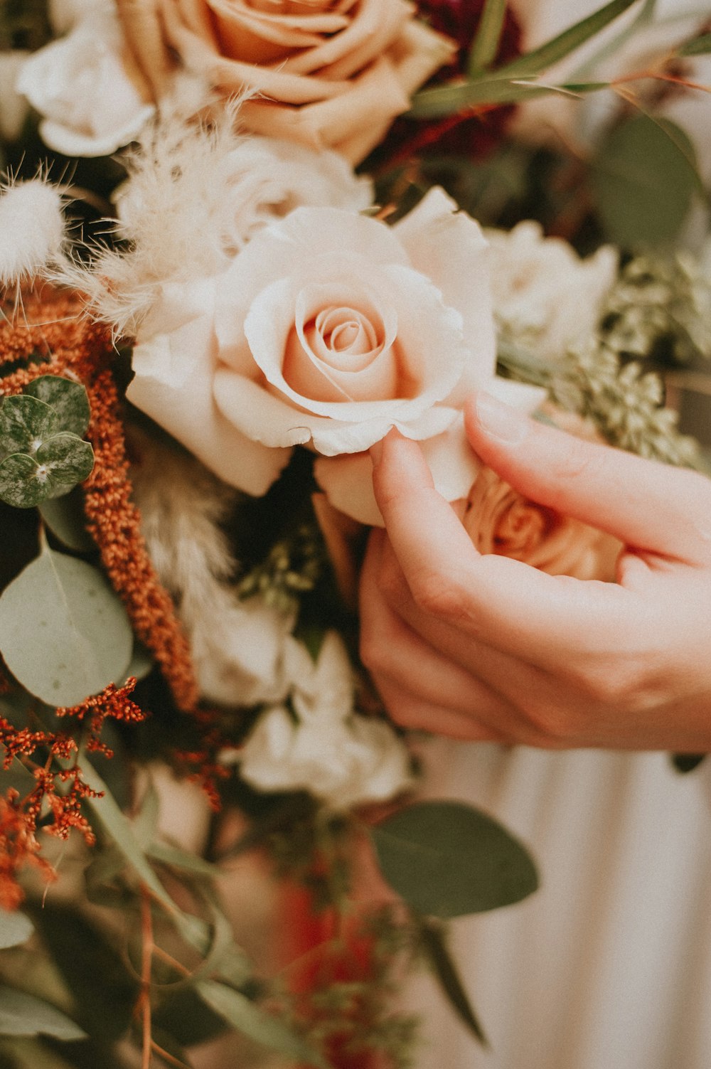 a close up of a person holding a bouquet of flowers