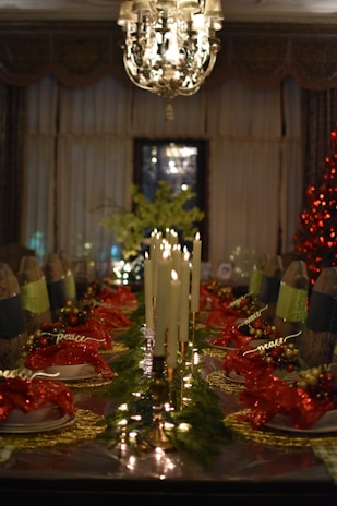 A festive dining table set for a Christmas feast with candles and decorations.