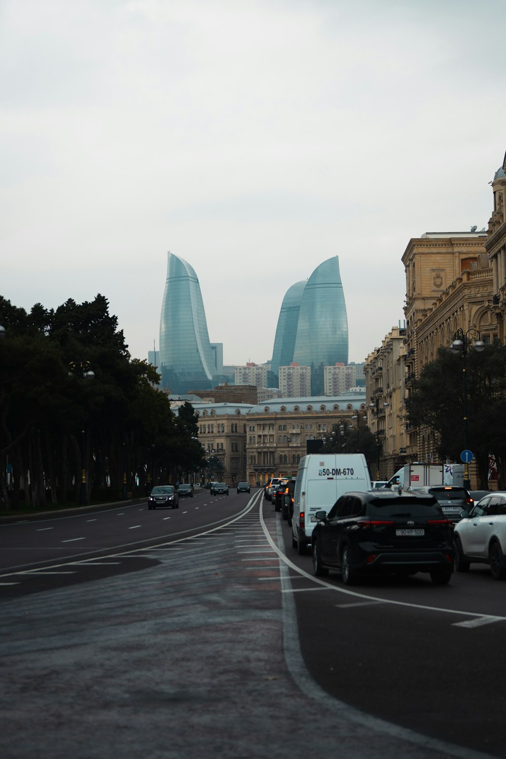 a city street filled with lots of traffic next to tall buildings