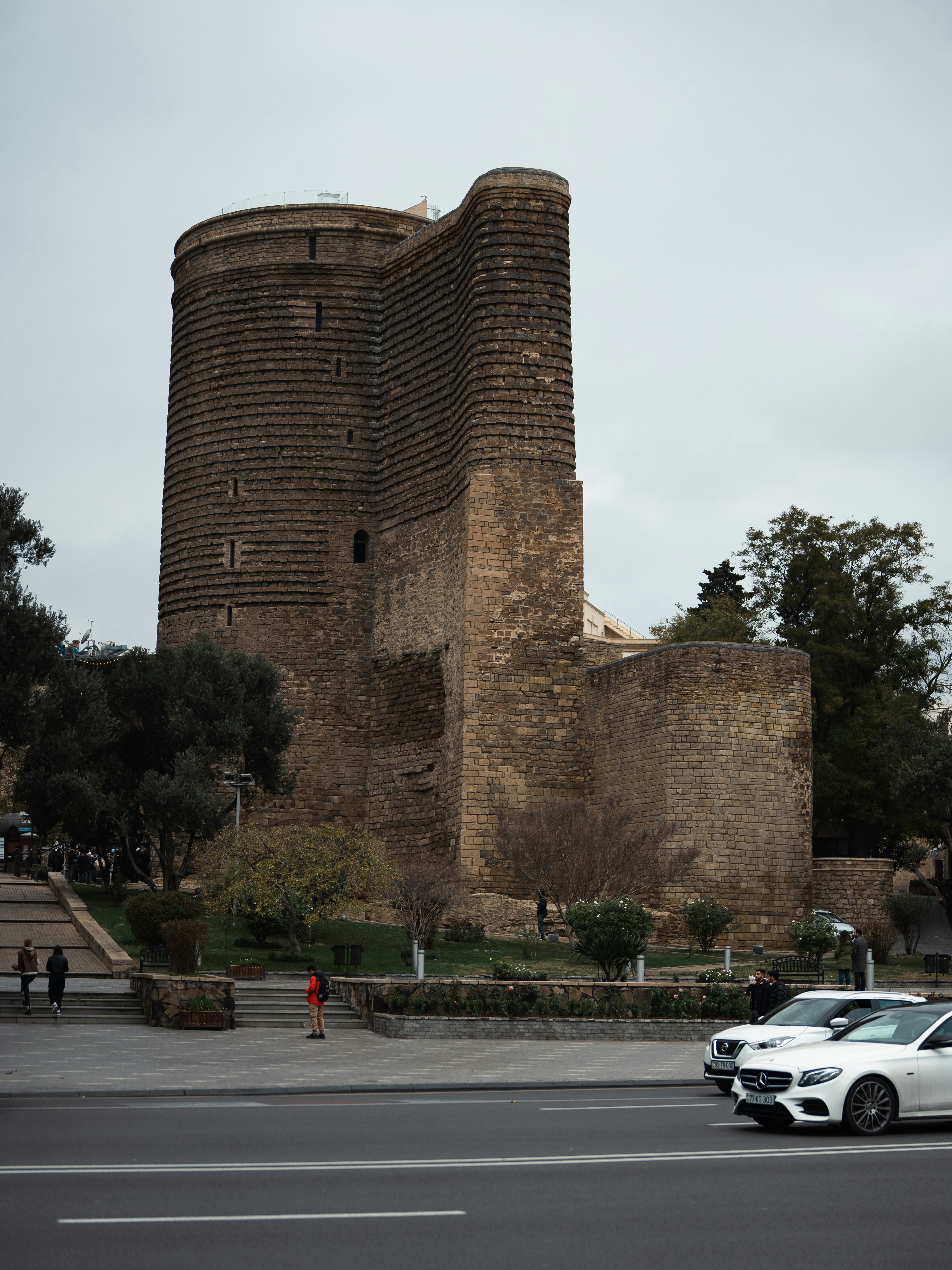 a white car driving down a street next to a tall brick building