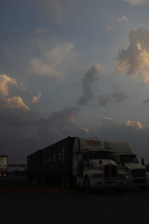 A convoy of Logancrest trucks lined up under a moody charcoal sky.