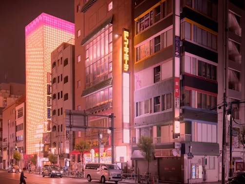 A cinematic view of a bustling global city street at night with neon pink accents.