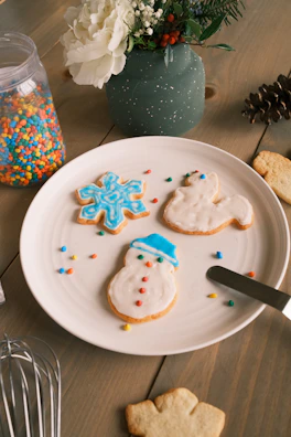 Festive holiday cookies decorated with icing and sprinkles on a festive plate