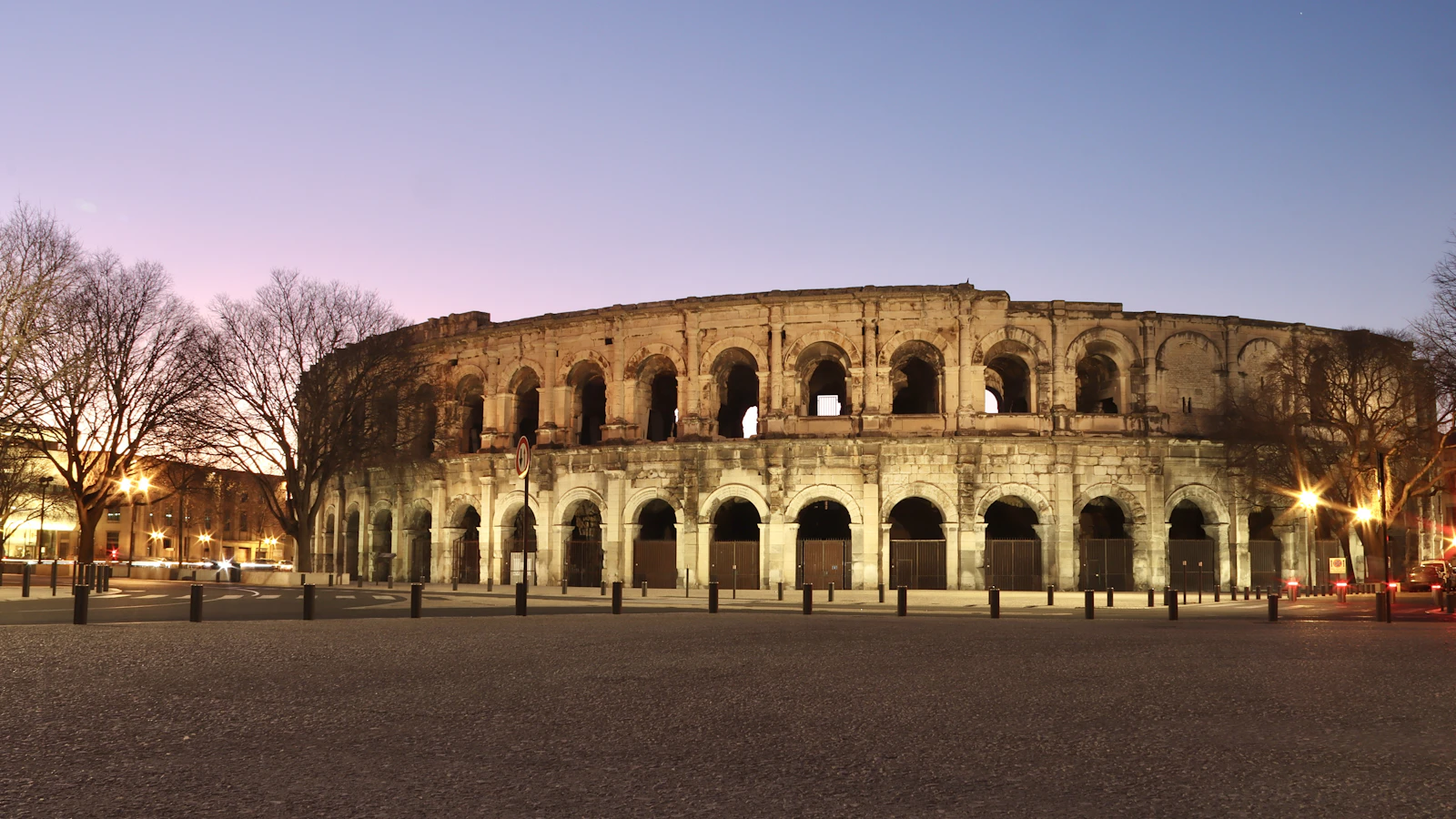 The Roman arena lit at dusk — Nîmes, France