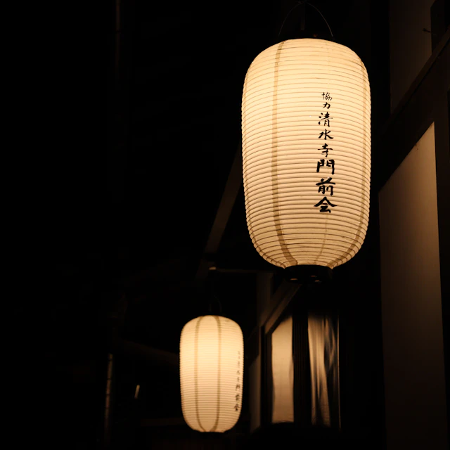 A couple of white paper lanterns hanging from a ceiling