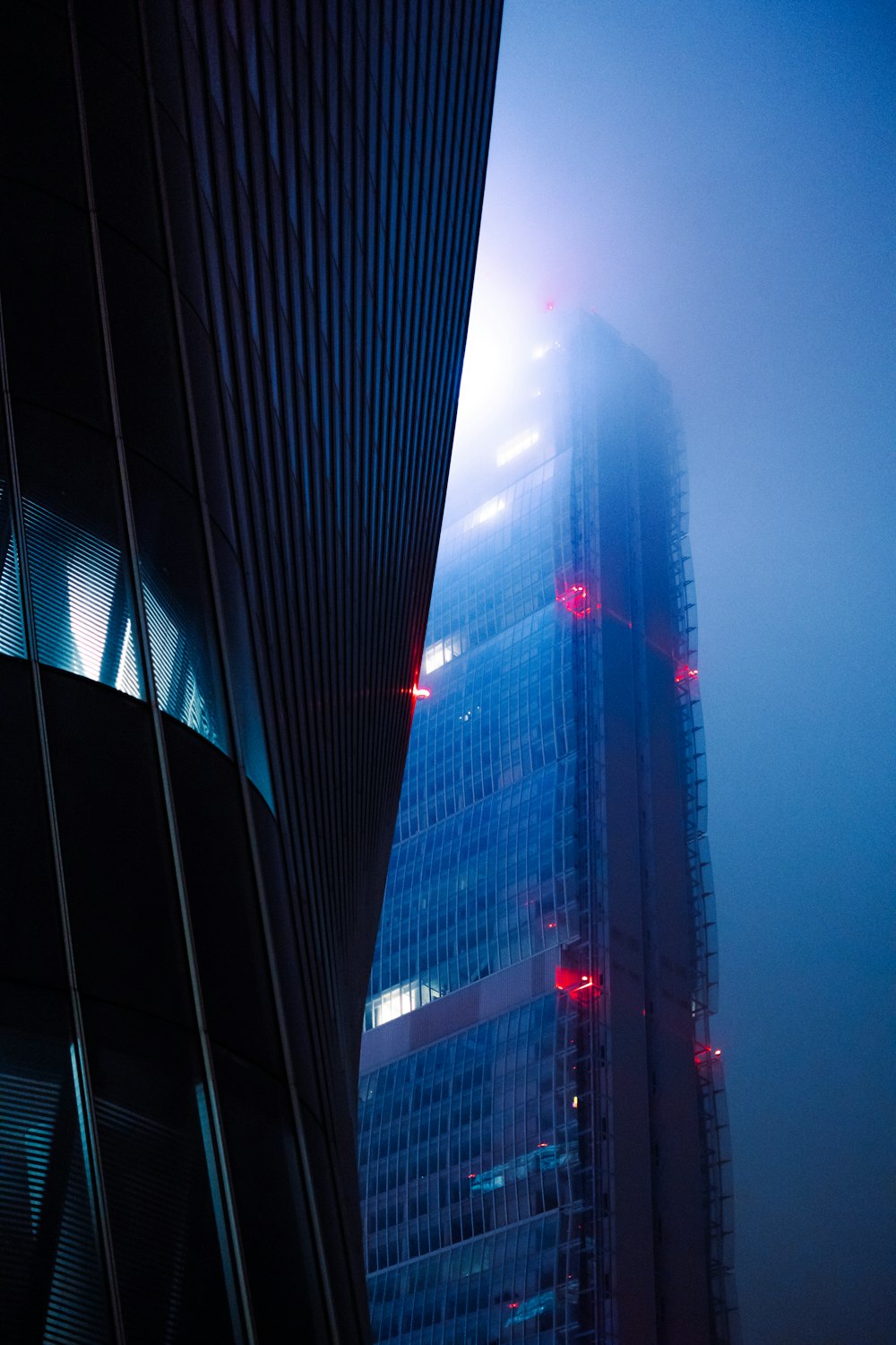 a very tall building in the middle of a foggy sky