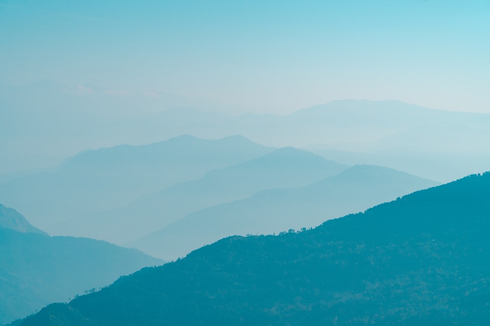 a view of a mountain range from the top of a hill