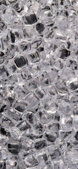 Close-up of clear ice blocks stacked neatly in a factory setting